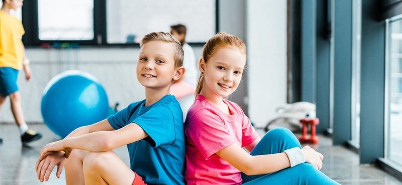 Poika ja tyttö liikuntasalissa
